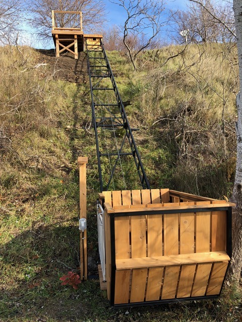 The lift blends into the existing terrain. We attached the lower button-box post to the track, and the client's electrician used the lift to mount a pony panel at the top and an outlet at the bottom. Even though the station buttons are protected by silicone boots, we turned the post so the buttons face the leeward side. No lower-station platform was required.