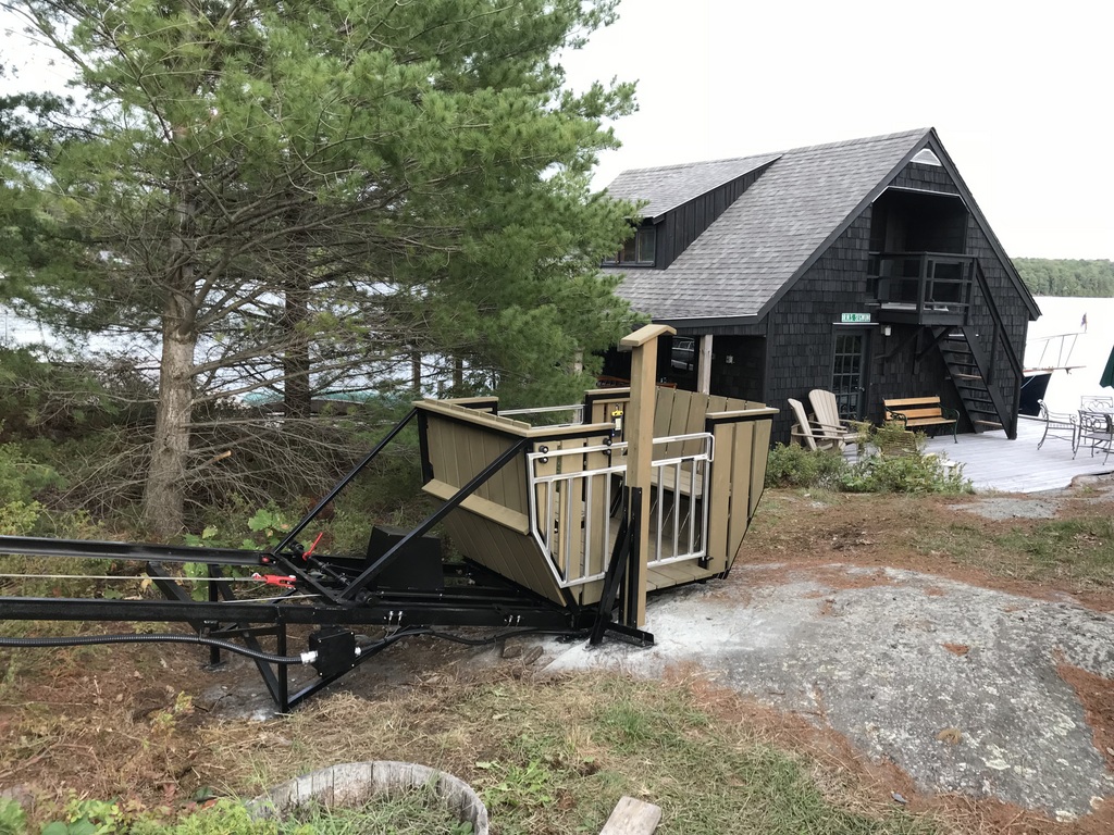 The boathouse is a few easy paces away. We used the natural stone step at the bottom end as the lower-station platform and attached the button-box post to a bracket fixed to the rock and the track.