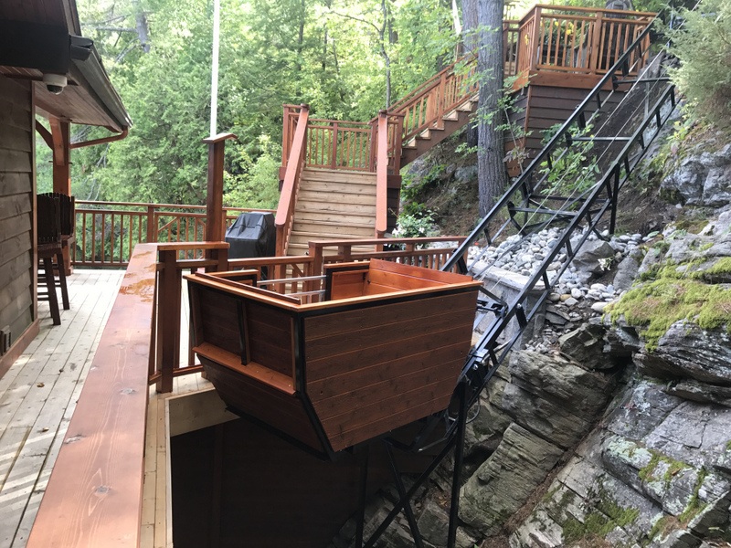 The track hardly intrudes on the natural amphitheatre formed by the rock wall and the boathouse deck. The PARK button moves the car 15 feet up the track, where it is hidden but handy.