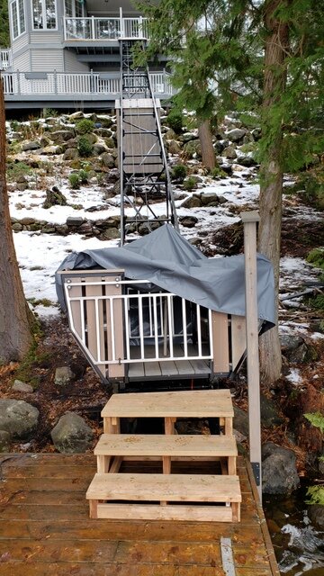 We needed to mount the car on top of the dolly so that people could get on and off along the line of the track in the upper station, which meant the car floor could not sit level with the dock at the bottom. We built two steps and a platform for access at the lower station. The owner built a cover, which we had partially removed for this photo.