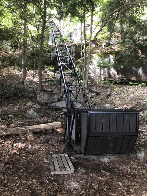 It is 168 vertical feet, 300 horizontal feet, and 240 scenic seconds to the cottage from here. The lower button-box post is welded directly to the track to minimize the station's footprint on the environment. Because users at the top cannot see the lower station, we designed a self-closing gate attached to the button-box post: if the gate is open, the car will not move. The PARK button moves the car about 20 feet up the track and deactivates the lift, keeping it out of harm's way and safe from unauthorized use. The lift has a tiny footprint.